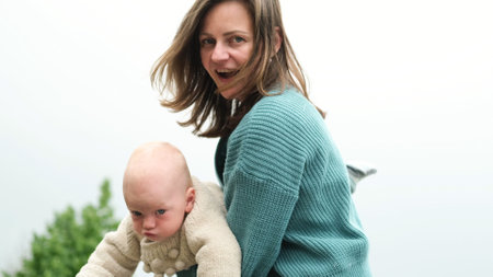 A woman and a little boy on a walk by the river. Mother holds her son in her arms.