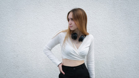 Photo of a beautiful young teen girl in long hair standing against a white wallの写真素材