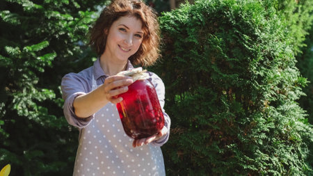 A woman prepares canned compotes for the winter. On a warm autumn day, a housewife does household...