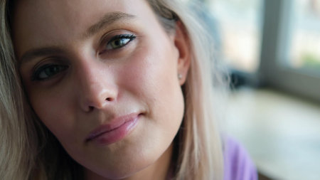 Beautiful young blonde woman smiling and looking at the camera. Woman looking relaxed, friendly and happyの写真素材