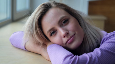 Beautiful young blonde woman smiling and looking at the camera. Woman looking relaxed, friendly and happyの写真素材