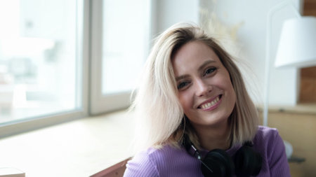 Beautiful young blonde woman smiling and looking at the camera. Woman looking relaxed, friendly and happyの写真素材