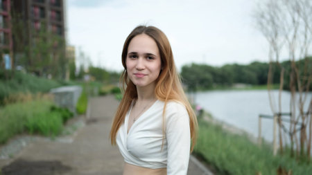 Beautiful teen girl looks into the camera. Close-up portrait outdoors.の写真素材