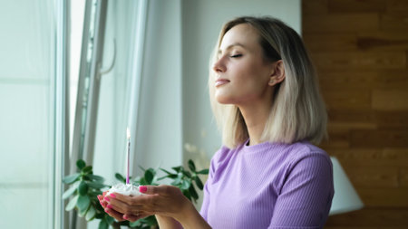 A beautiful young blonde woman wearing a homemade purple suit, holding a festive cupcake with a...