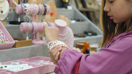 A little fashionista is shopping at a jewelry store in a large shopping center. A cute little girl...