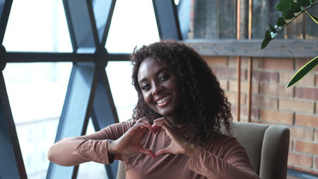 Portrait of a cute African American woman with a beautiful smile, with long curly hair. A woman...