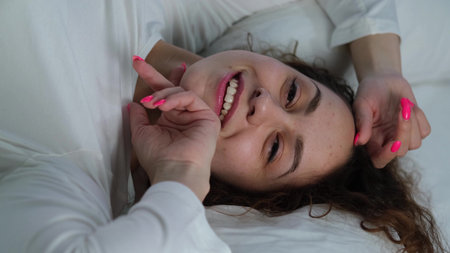Young woman sleeping in bed. Portrait of a beautiful woman resting on a comfortable bed with pillows...