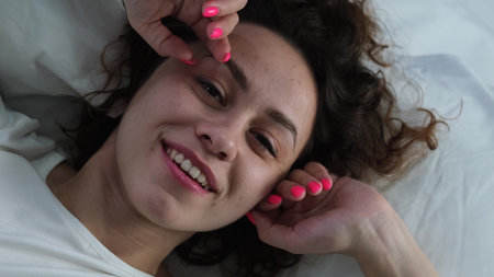 Young woman sleeping in bed. Portrait of a beautiful woman resting on a comfortable bed with pillows...