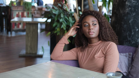 A woman poses in a restaurant. A business student, a young professional, is sitting at a table in a...