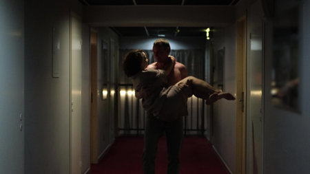 Romantic evening for a married couple. A man carries his beloved woman in his arms in the sad...