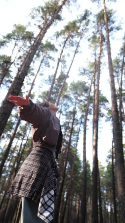Young beautiful woman enjoying relaxation in the forest, breathing fresh air at sunset
