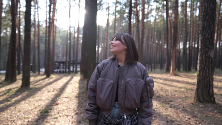Young beautiful woman enjoying relaxation in the forest, breathing fresh air at sunsetの写真素材