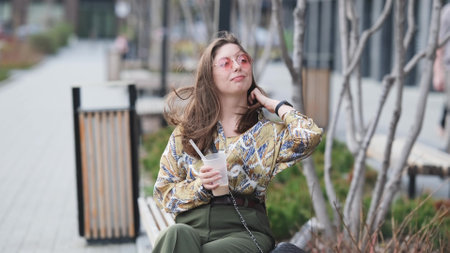 Pensive happy woman sipping a milkshake in the streetの写真素材