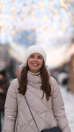 Portrait of a beautiful young woman in winter clothes. The woman smiles happily against the...