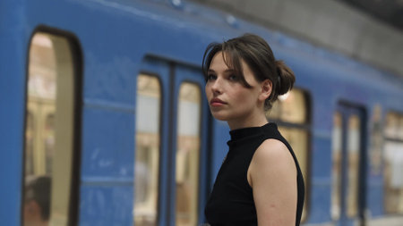 Brunette stands at the metro station waiting for the train to arriveの写真素材