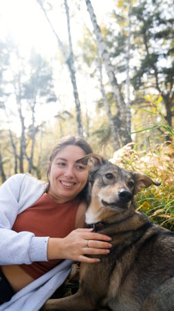 Young woman with a dog in an autumn forest