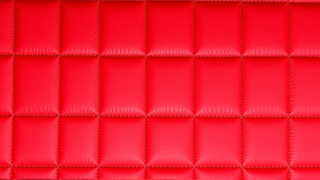 The surface texture of artificial leather in red, stitched in the form of rhombuses, squares, rectangles. Quilted eco-leather.の素材