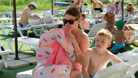 Happy mother and son relax on the beach and enjoy a warm beautiful day.の写真素材