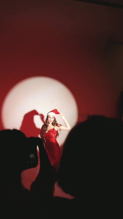 Happy woman with long hair in New Years hat and red dress posing on white background at New Years party style photo shootの写真素材
