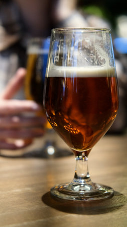 Close-up of two glasses of beer on a table, blurred backgroundの写真素材