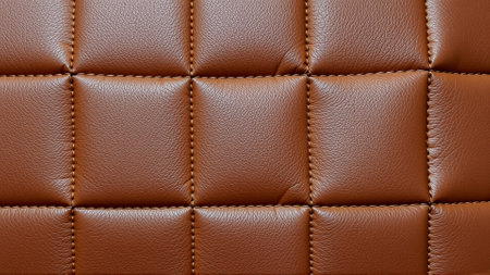 The surface texture of artificial leather is brown, stitched in the form of diamonds, squares, rectangles. Quilted eco-leather.の素材