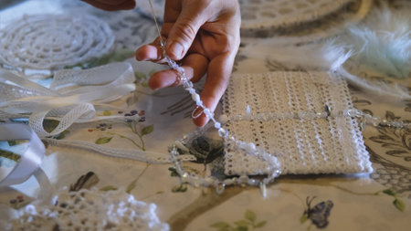Woman making dreamcatcher from threads, feathers, beads and silk ribbons, making home decor items, handmade amuletの写真素材