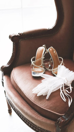 White gloves and sandals are lying on a chair. The concept of preparing for a wedding. Morning of the brideの写真素材