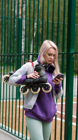 Blonde woman walking through city park holding roller skates enjoying beautiful day