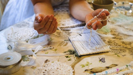 Woman making dreamcatcher from threads, feathers, beads and silk ribbons, making home decor items, handmade amuletの写真素材