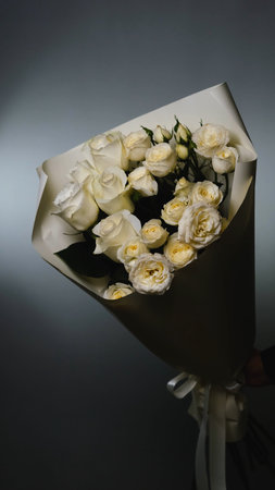 Beautiful white roses in a flower shop. Florist assembles a bouquet to orderの写真素材
