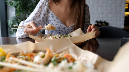 Close-up of Caucasian woman eating pan-Asian cuisineの写真素材