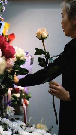 Beautiful white roses in a flower shop. Florist assembles a bouquet to order