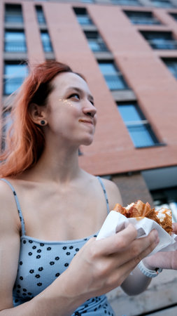 Teen girl eating hamburger outdoors. Fast food concept.
