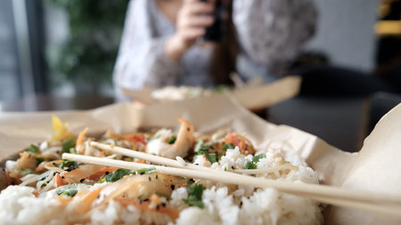 Close-up of Caucasian woman eating pan-Asian cuisineの写真素材