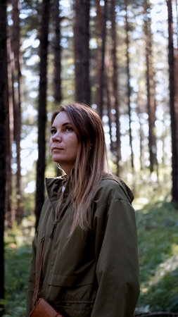 Portrait of a woman breathing fresh air in an autumn forest. The woman enjoys a walk in the forest...