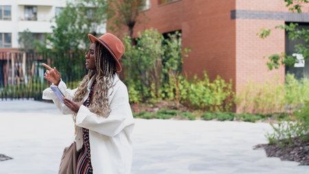 A woman uses a city map and geolocation on her smartphone to navigate the area while traveling.の写真素材