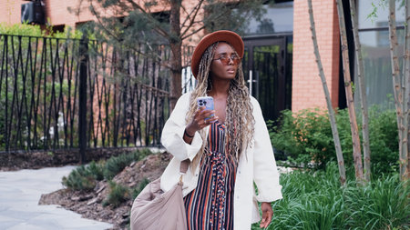 A woman uses a city map and geolocation on her smartphone to navigate the area while traveling.の写真素材