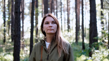 Portrait of a woman breathing fresh air in an autumn forest. The woman enjoys a walk in the forest and a beautiful warm dayの写真素材