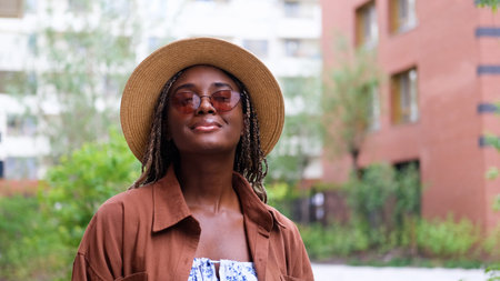 Young woman resting and relaxing while walking on city street in new eco-friendly residential complex. Relaxation and stress-free concept.の写真素材