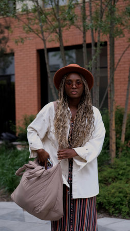 Young woman resting and relaxing while walking on city street in new residential complex. Relaxation...