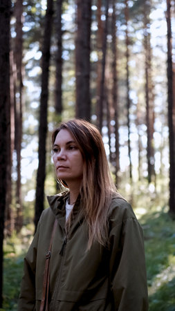 Portrait of a woman breathing fresh air in an autumn forest. The woman enjoys a walk in the forest...