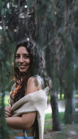 Portrait of a very beautiful young woman in a summer spruce forest at sunset.の写真素材