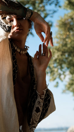 A brunette dressed in boho style meditates and dances in the forest. A ritual takes place against a green forest backdrop.の写真素材