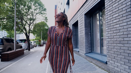 Young woman resting and relaxing while walking on city street in new eco-friendly residential complex. Relaxation and stress-free concept.の写真素材