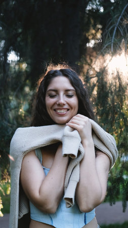 Portrait of a very beautiful young woman in a summer spruce forest at sunset.の写真素材