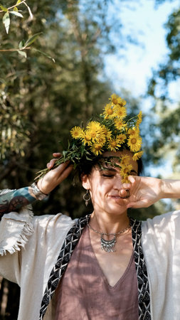 Beautiful brunette in boho style holds a bouquet of yellow flowers in her handsの写真素材