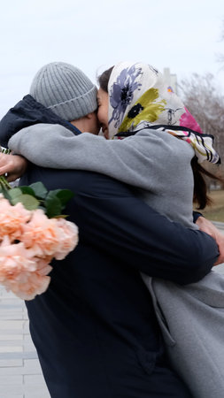 A loving couple hugs and twirls during a walk through the city during the cold season.