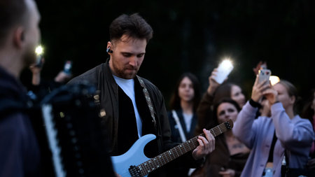 September 15, 2025. Russia, Novosibirsk. Street musicians perform in a city park during the summer sunset.のeditorial素材