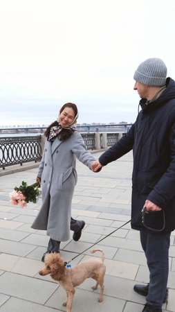 A couple hugs and twirls during a walk through the city during the cold season.の写真素材
