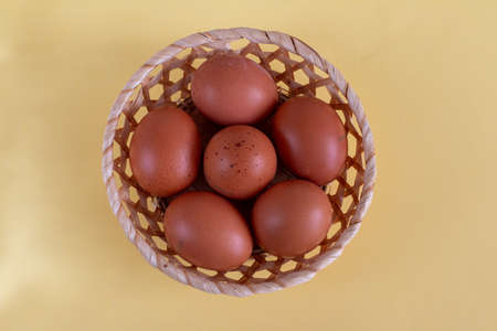 group of brown eggs on a yellow table